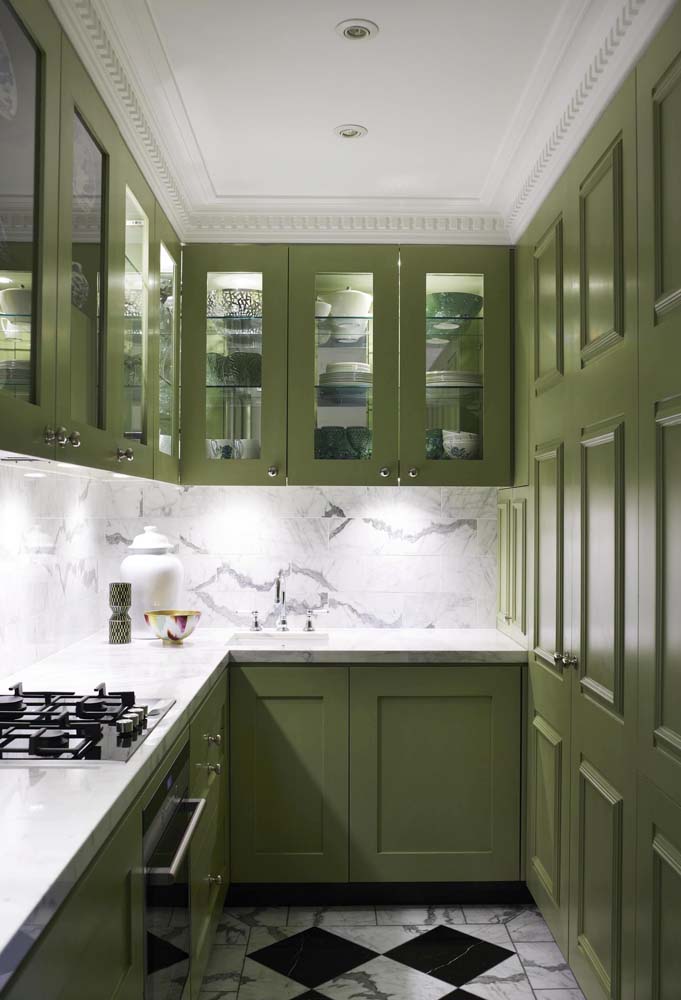 Nessa cozinha estreita, a iluminação localizada impede que os armários verde musgo deixem o ambiente escuro e desconfortável.