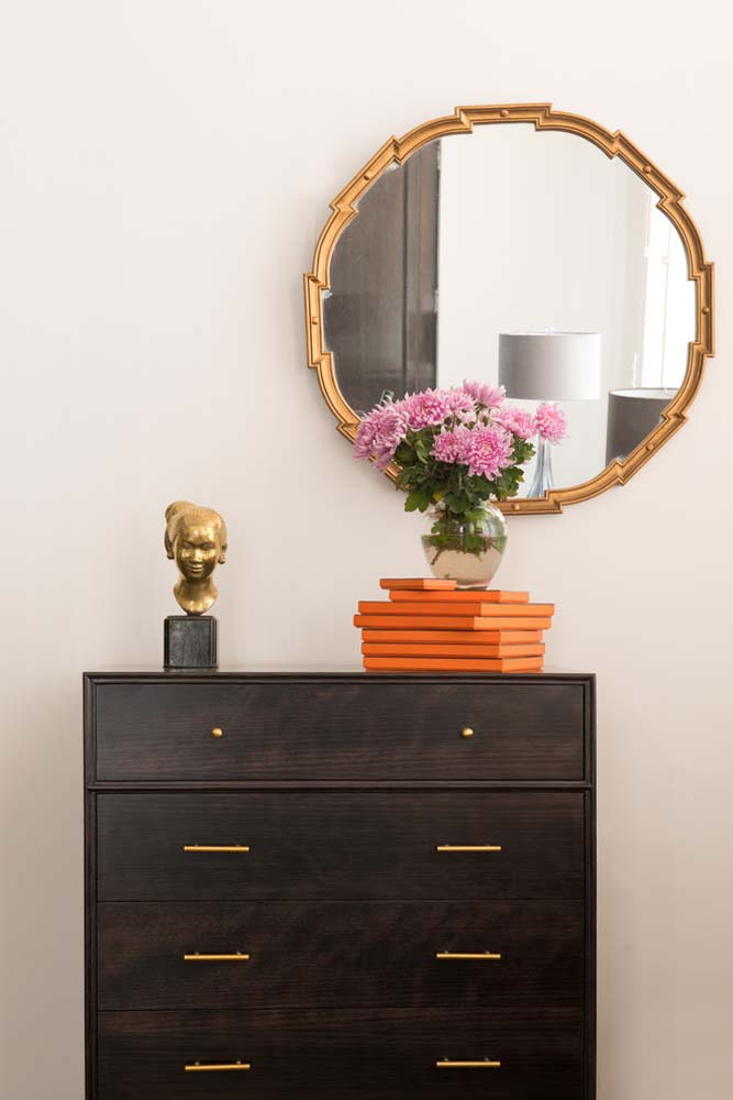 Já num visual minimalista, temos essa cômoda rústica escura com dois tipos de puxadores dourados: redondinhos para a primeira gaveta e numa linha reta para as demais.