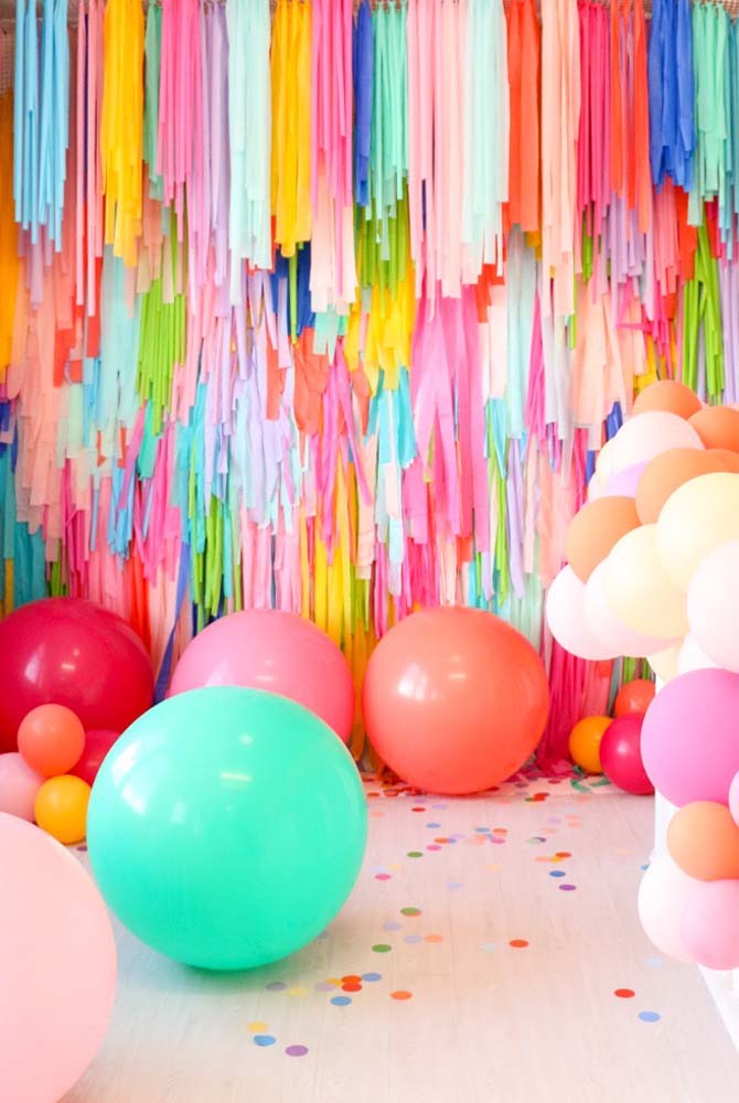 Balões e um painel de tiras de papel: decoração de festa de 20 anos simples