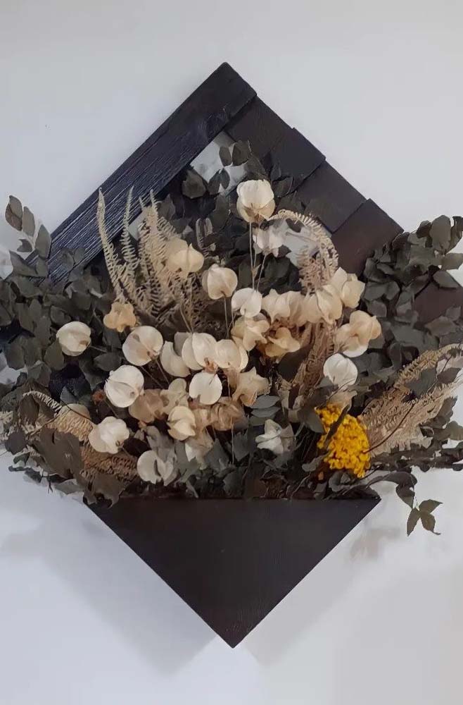 Floreira de pallet em forma de losango com um vaso triangular, tudo em preto.