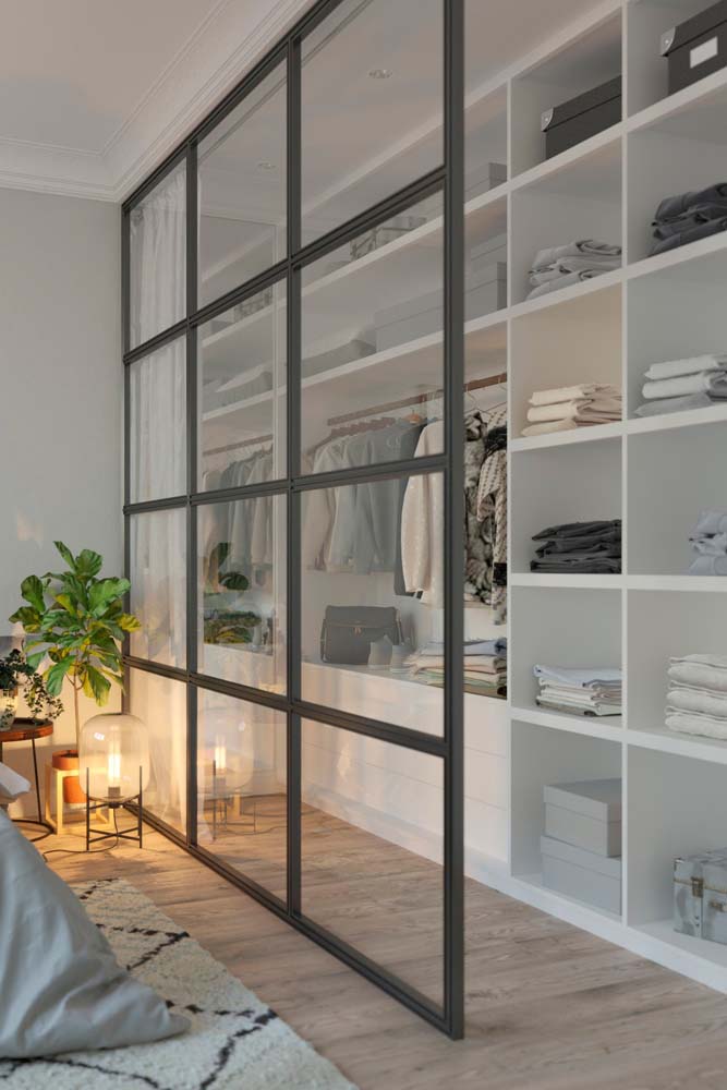 O closet com guarda roupa de gesso é separado da área principal do quarto por uma parede de vidro - e que pode ser isolada com ajuda da cortina.