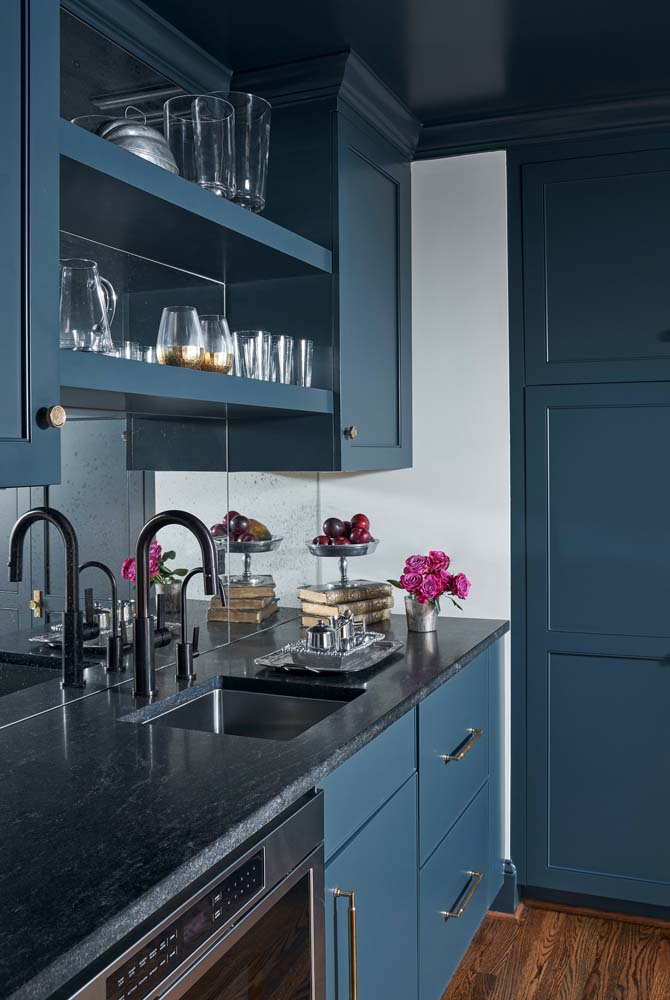 Já nessa cozinha elegante, o charme fica por conta do tom de azul que harmoniza com o granito preto