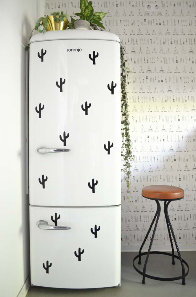 Adesivos de cacto e vasos de plantas reais formam a decoração da geladeira neste exemplo.