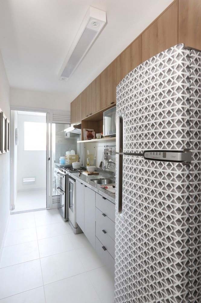 Nesta cozinha simples, todos os olhares se voltam para a geladeira envelopada com padrão triangular em branco e cinza.