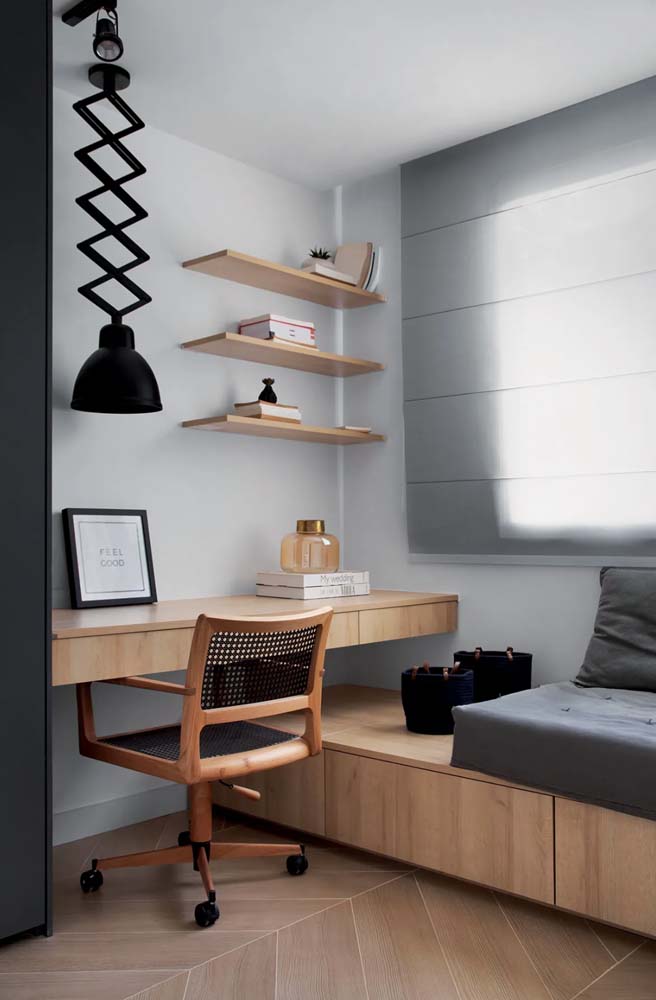Falando em móveis planejados de madeira, confira essa ideia de escritório com mesa suspensa e plataforma com assento tipo futon e almofadas