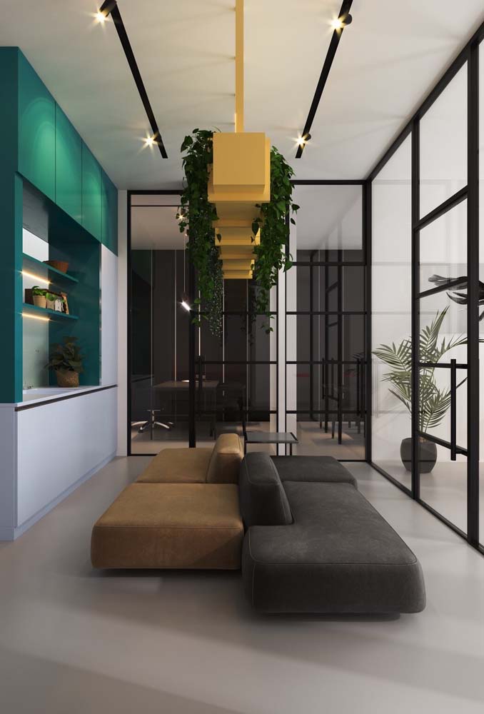 A combinação de sofás modernos garante espaço para todo mundo nesta área de descanso do escritório.